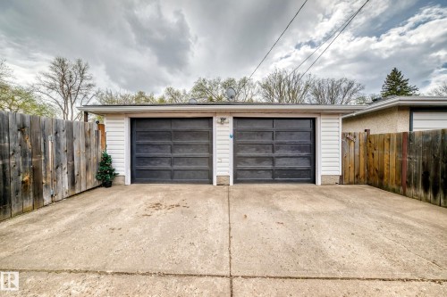 Two-car detached garage with dark paneled doors and white siding - 4006 115 Avenue, Edmonton, AB 