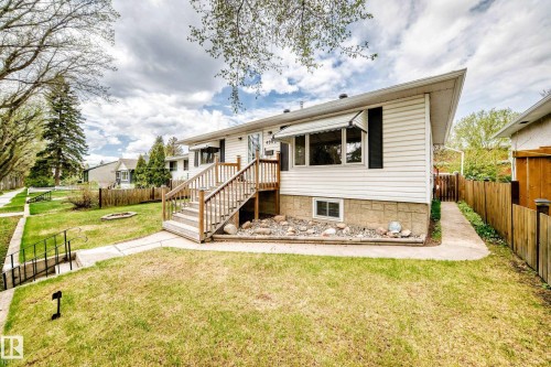 White siding exterior with a wood-stained entryway deck and stairs - 4006 115 Avenue, Edmonton, AB 