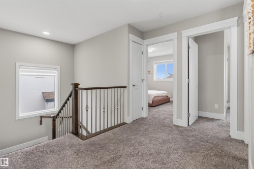 Upper-level landing featuring plush gray carpeting, crisp white trim, and a window with roller blinds - 3312 11 Avenue, Edmonton, AB - Indoor Photo Showing Other Room