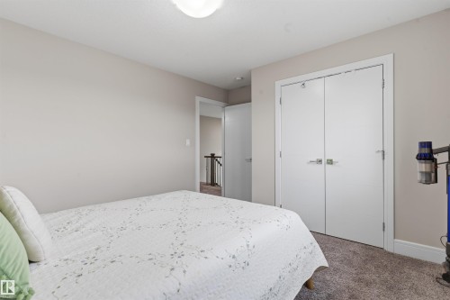 Carpeted room featuring a double-door closet with modern hardware, neutral wall paint, and a ceiling-mounted light fixture - 3312 11 Avenue, Edmonton, AB - Indoor Photo Showing Bedroom