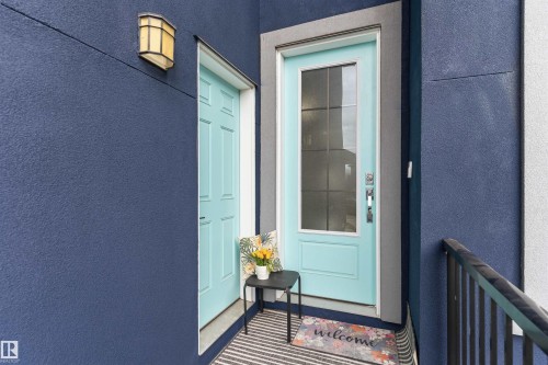 Entryway featuring a light blue door with glass panels and a chrome handle, complemented by an overhead wall sconce - 3312 11 Avenue, Edmonton, AB - Outdoor With Exterior