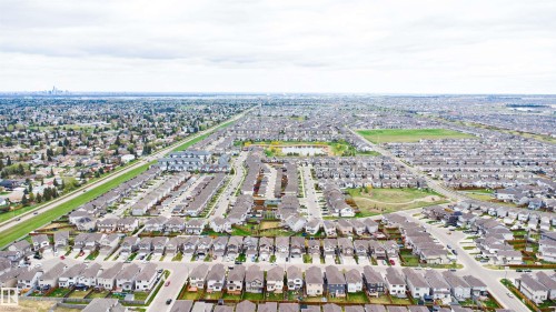 Expansive aerial perspective showcasing a residential development featuring numerous single-family homes and townhomes - 3312 11 Avenue, Edmonton, AB - Outdoor With View