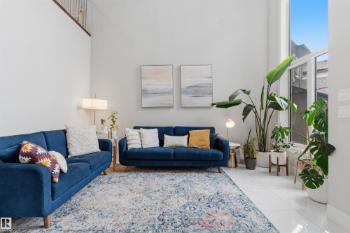 Spacious living area featuring high ceilings, tall windows, and polished tile flooring - 3312 11 Avenue, Edmonton, AB - Indoor Photo Showing Living Room
