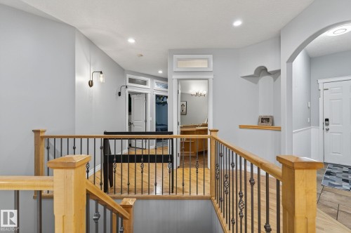 Hardwood flooring throughout the upper landing with wood handrails and wrought iron balusters - 34 Valleyview Ridge, Fort Saskatchewan, AB - Indoor Photo Showing Other Room