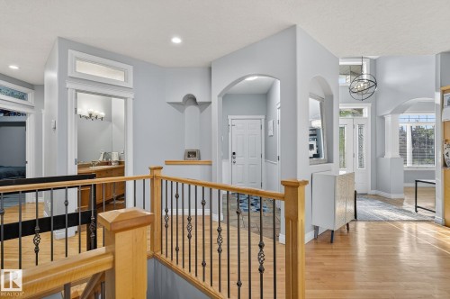 Upper landing featuring wood-finish flooring, wrought iron balusters, and arched doorways - 34 Valleyview Ridge, Fort Saskatchewan, AB - Indoor Photo Showing Other Room