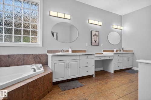Dual vanity with white cabinetry and integrated sinks, complemented by contemporary wall-mounted lighting - 34 Valleyview Ridge, Fort Saskatchewan, AB - Indoor Photo Showing Bathroom