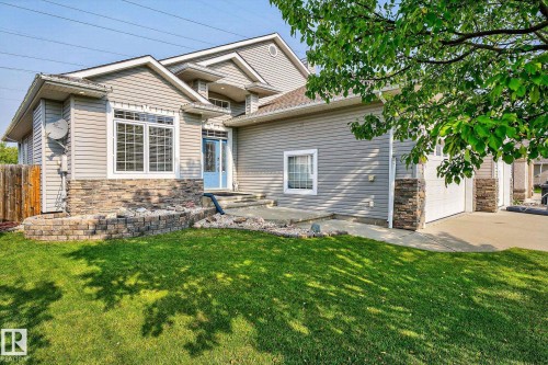 Modern gray siding exterior with stone accents and a light blue entry door - 34 Valleyview Ridge, Fort Saskatchewan, AB - Outdoor