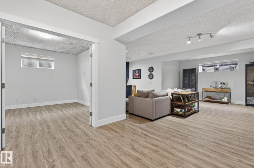 Spacious lower-level area featuring wood-finish flooring throughout - 34 Valleyview Ridge, Fort Saskatchewan, AB - Indoor