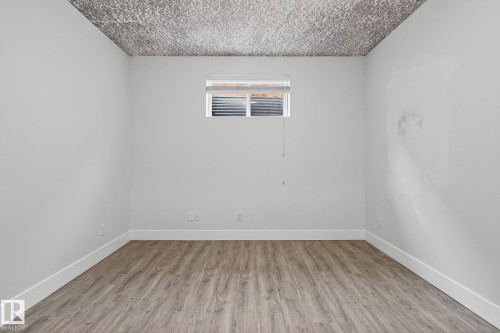 Room featuring wood-finish flooring, white baseboards, and a window with blinds - 34 Valleyview Ridge, Fort Saskatchewan, AB - Indoor Photo Showing Other Room