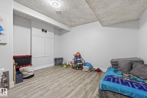 Spacious room featuring wood-finish flooring, light gray walls, and a textured ceiling - 34 Valleyview Ridge, Fort Saskatchewan, AB - Indoor
