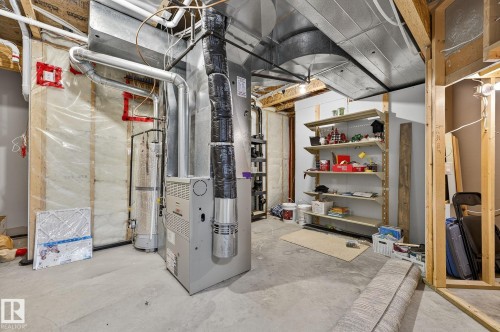 Utility room featuring a furnace, water heater, exposed ductwork, concrete flooring, and built-in shelving - 34 Valleyview Ridge, Fort Saskatchewan, AB - Indoor Photo Showing Basement