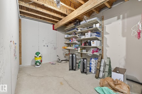 Unfinished basement space featuring exposed wood joists, concrete flooring, and built-in shelving - 34 Valleyview Ridge, Fort Saskatchewan, AB - Indoor Photo Showing Basement