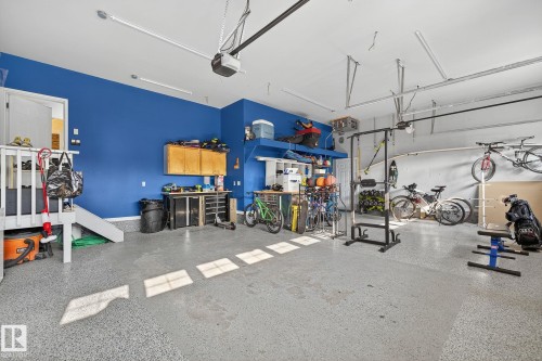 Spacious garage featuring a durable epoxy floor, integrated workbench, and built-in shelving - 34 Valleyview Ridge, Fort Saskatchewan, AB - Indoor Photo Showing Other Room