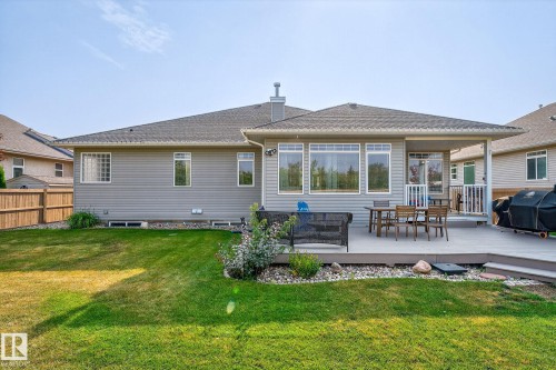 Spacious backyard featuring a large composite deck, covered patio area, and expansive lawn - 34 Valleyview Ridge, Fort Saskatchewan, AB - Outdoor With Deck Patio Veranda With Exterior