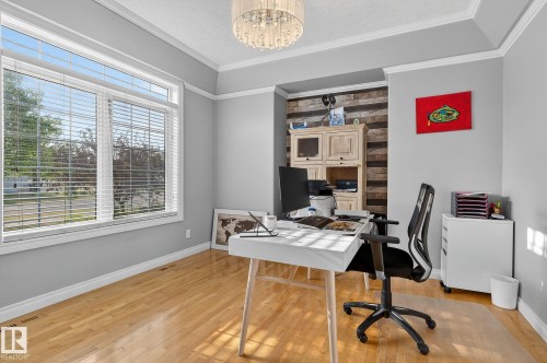 Bright room featuring hardwood flooring, a large window with white blinds, a tray ceiling, and a prominent accent wall with horizontal wood plank paneling - 34 Valleyview Ridge, Fort Saskatchewan, AB - Indoor Photo Showing Office