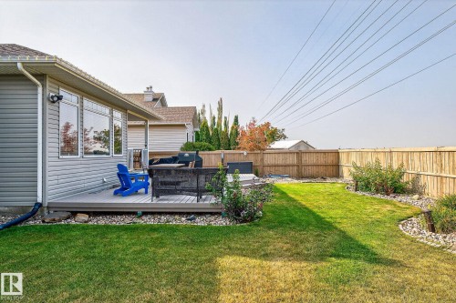 Fenced backyard featuring a composite deck, green lawn, and rock landscaping - 34 Valleyview Ridge, Fort Saskatchewan, AB - Outdoor