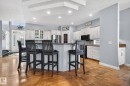 Kitchen island with a natural stone countertop, white shaker cabinetry, stainless steel appliances, and tile flooring - 34 Valleyview Ridge, Fort Saskatchewan, AB  - Indoor 