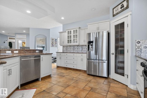 Kitchen featuring warm-toned tile flooring, white cabinetry, and stainless steel appliances - 34 Valleyview Ridge, Fort Saskatchewan, AB - Indoor Photo Showing Kitchen With Upgraded Kitchen