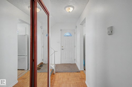 Entryway featuring parquet flooring, white walls, and a light fixture - 6F Castle Terrace, Edmonton, AB - Indoor Photo Showing Other Room