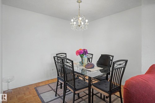 Dining area featuring a chandelier, white walls, and hardwood flooring - 6F Castle Terrace, Edmonton, AB - Indoor Photo Showing Dining Room
