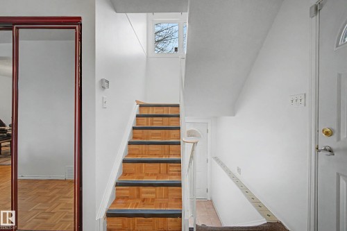 The property features a staircase with wood flooring and a window that provides natural light - 6F Castle Terrace, Edmonton, AB - Indoor Photo Showing Other Room