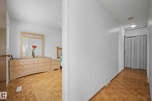 The property features wood parquet flooring throughout the bedroom and hallway - 6F Castle Terrace, Edmonton, AB - Indoor Photo Showing Other Room