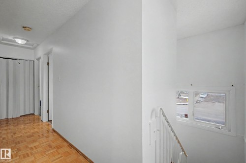 The property features a staircase with a white railing and a window providing natural light - 6F Castle Terrace, Edmonton, AB - Indoor Photo Showing Other Room