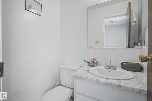 The bathroom features a white vanity with a marble-patterned countertop, an integrated sink, and a large wall-mounted mirror - 6F Castle Terrace, Edmonton, AB - Indoor Photo Showing Bathroom