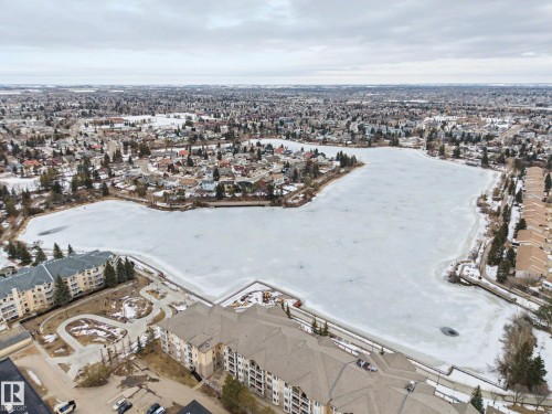 Aerial view showcasing the property's proximity to a frozen body of water, surrounded by residential areas and trees - 6F Castle Terrace, Edmonton, AB - Outdoor With View
