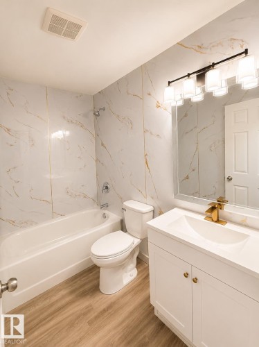 White vanity with gold-tone hardware and single-hole faucet - 13833 24 Street Nw, Edmonton, AB - Indoor Photo Showing Bathroom