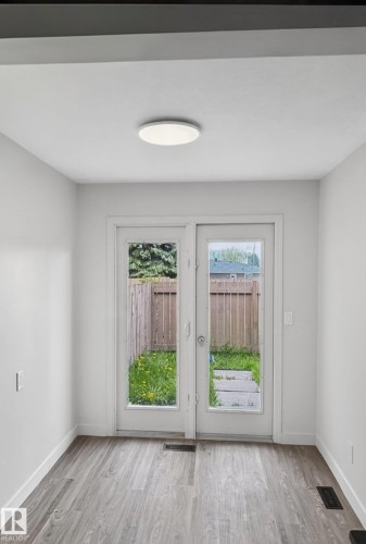 Dual French doors opening to an outdoor area with a wooden fence - 13833 24 Street W, Edmonton, AB - Indoor Photo Showing Other Room