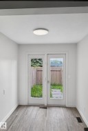 Dual French doors opening to an outdoor area with a wooden fence - 
