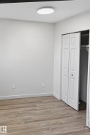 Room featuring wood-finish flooring, white walls, and a recessed ceiling light - 