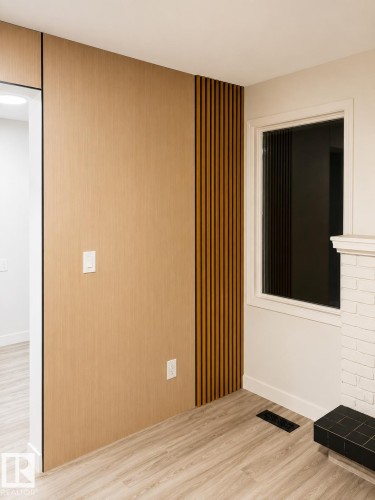Wood-finish flooring with white baseboards - 13833 24 Street Nw, Edmonton, AB - Indoor Photo Showing Other Room