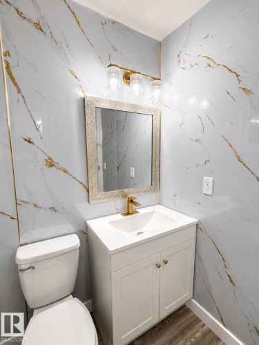 White vanity with gold hardware, integrated sink, and gold-finish faucet - 13833 24 Street Nw, Edmonton, AB - Indoor Photo Showing Bathroom