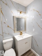 White vanity with gold hardware, integrated sink, and gold-finish faucet - 