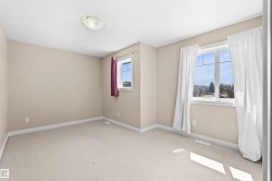 Room featuring two windows, neutral wall tones, and carpeted flooring - 