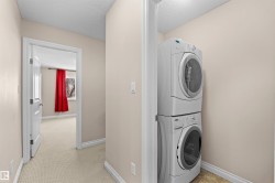 Dedicated laundry area featuring a stacked washer and dryer unit - 