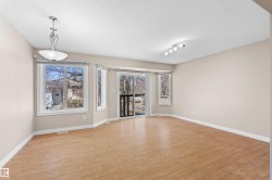 Spacious room featuring wood-finish flooring, neutral-toned walls, and multiple windows - 