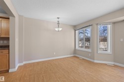 Open-concept dining area featuring wood-finish flooring, neutral wall tones, and white baseboards - 