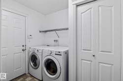 Dedicated utility space featuring a front-loading washer and dryer, a wire shelving unit, a paneled door, and a bi-fold door - 