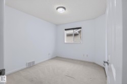 Room featuring light-toned carpeting and white painted walls - 