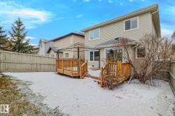 Rear exterior featuring a multi-level wood deck, light-colored siding, and a fenced perimeter - 