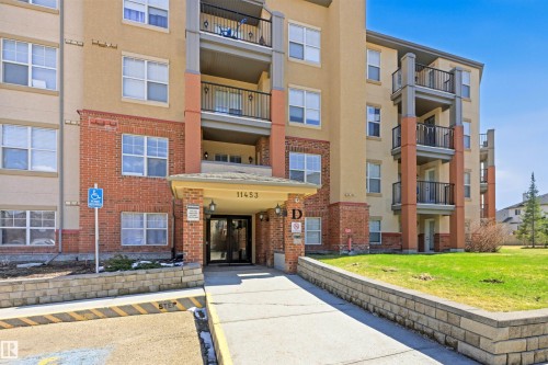 Multi-story building featuring a stucco and brick facade with multiple balconies - 407 11453 Ellerslie Road Sw, Edmonton, AB - Outdoor With Balcony With Facade