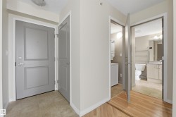 Entryway featuring a panel door with brushed nickel hardware, light-toned tile flooring, and light-colored walls - 