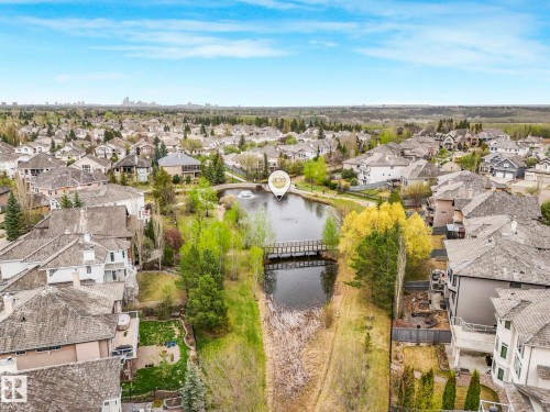 Aerial depiction of a residential area featuring a central pond with a fountain - 879 Drysdale Run Run, Edmonton, AB - Outdoor With View