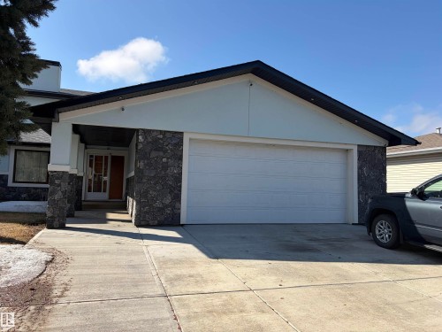 Stone facade with light-toned siding and a prominent two-car garage - 7007 10 Avenue, Edmonton, AB - Outdoor