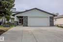 Stone facade with light-toned siding and a prominent two-car garage - 7007 10 Avenue, Edmonton, AB  - Outdoor 