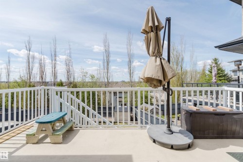 Spacious outdoor deck featuring a white spindle railing and a durable surface - 3412 Macneil Link, Edmonton, AB 