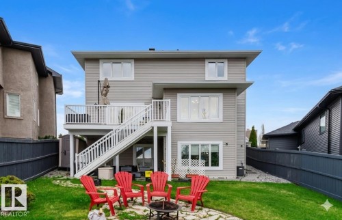 Rear exterior featuring a multi-level deck with white railings, light gray siding, and multiple windows - 3412 Macneil Link, Edmonton, AB 